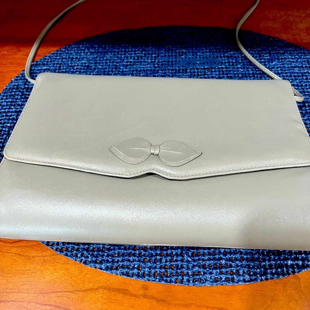 Vintage woman’s gray leather clutch with 17” leather drop handle, bow on front